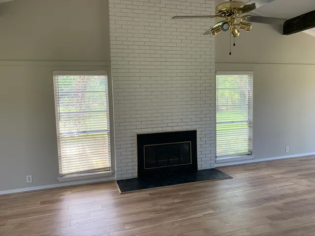a living room with a fireplace and wooden floor