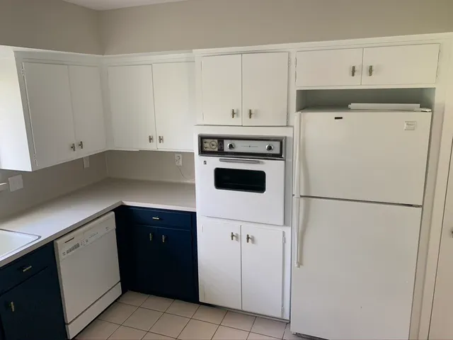a kitchen with a refrigerator sink and cabinets