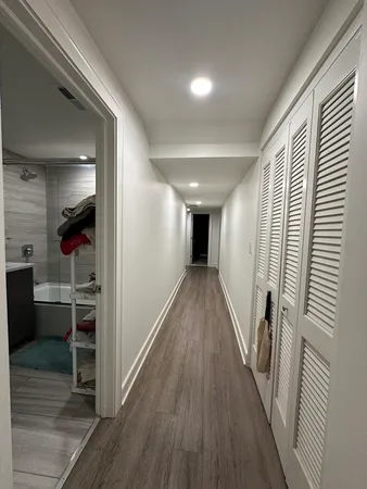 a view of a hallway with wooden floor and staircase