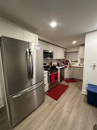 a kitchen with stainless steel appliances granite countertop a refrigerator stove and wooden floor