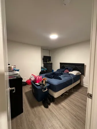 a bedroom with a bed and a wooden floor