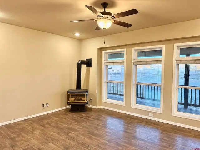 a view of a livingroom with wooden floor and a ceiling fan