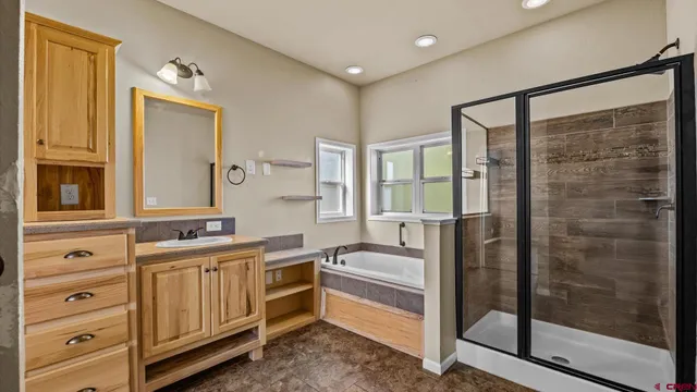 a bathroom with a double vanity sink a mirror a glass door and shower
