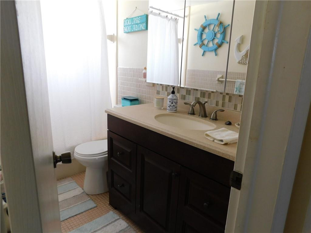 901 South Surf Road, Unit 306 Hollywood, FL 33019 - Photo 28 of 44 a bathroom with a granite countertop sink a toilet and a mirror