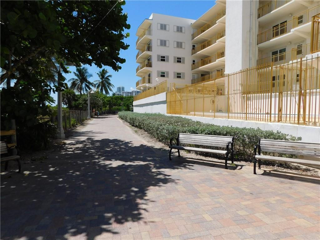 901 South Surf Road, Unit 306 Hollywood, FL 33019 - Photo 36 of 44 a backyard of a building with barbeque oven and bench