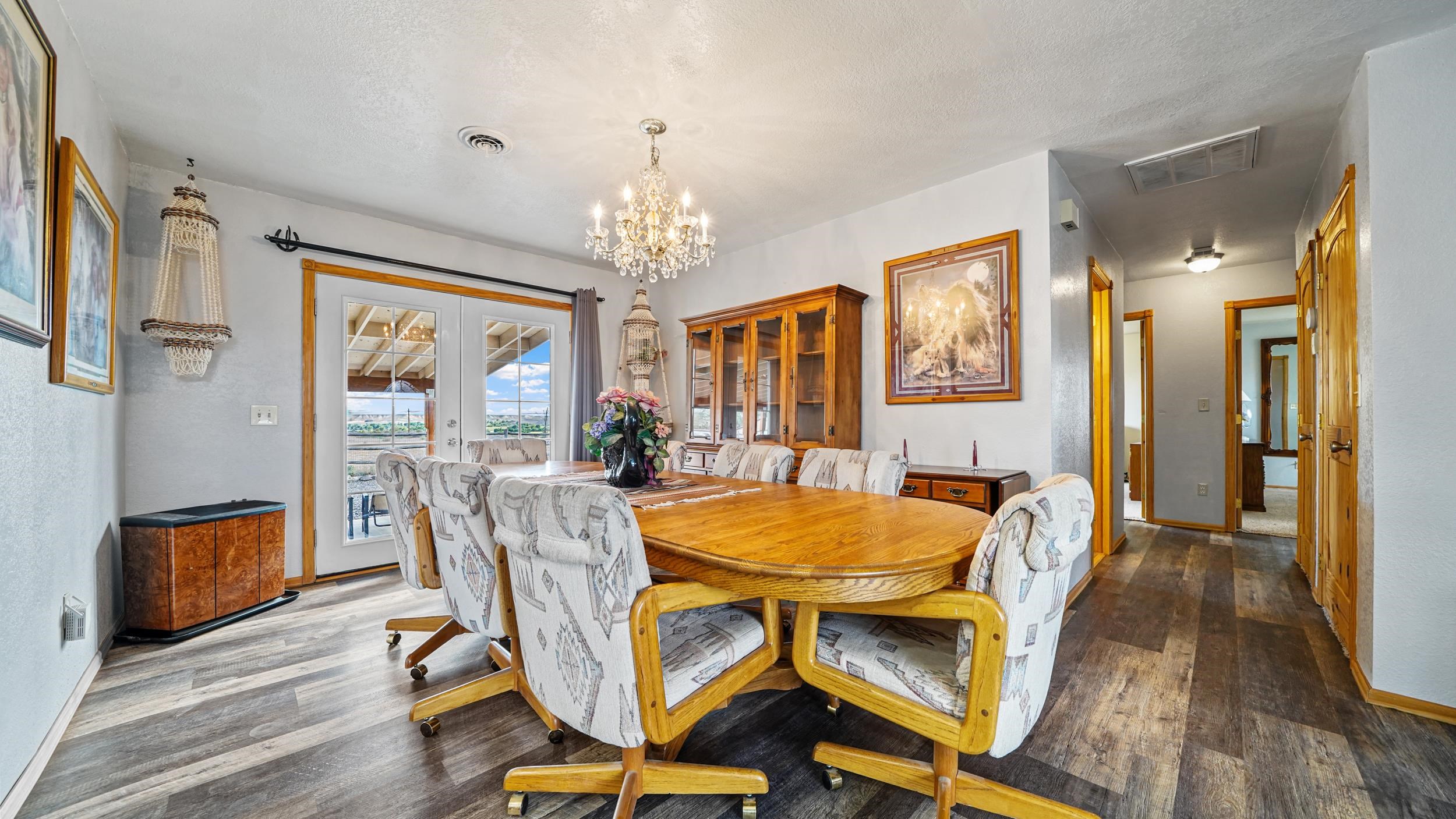 20786 Iris Road Austin, CO 81410 - Photo 14 of 38 a dining room with furniture a chandelier and wooden floor