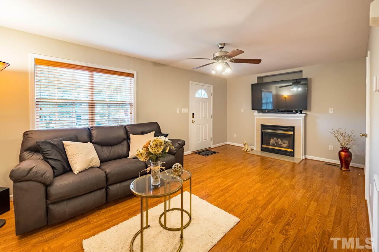 4917 Windproof Way Raleigh, NC 27616 - Photo 5 of 18 a living room with furniture a flat screen tv and a fireplace