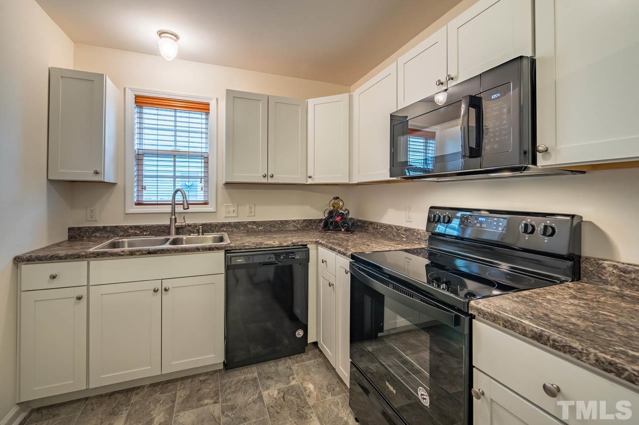 4917 Windproof Way Raleigh, NC 27616 - Photo 6 of 18 a kitchen with granite countertop a stove sink and microwave