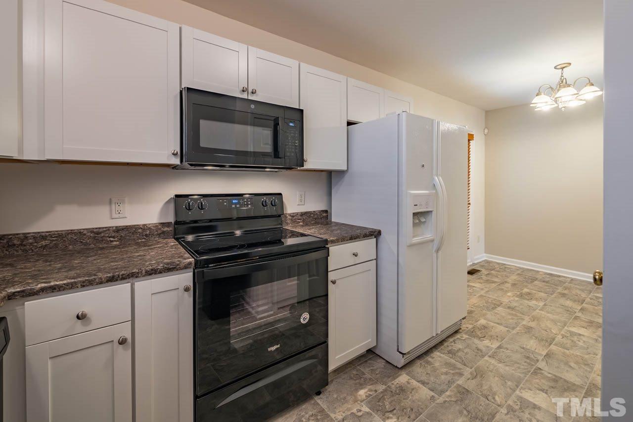 4917 Windproof Way Raleigh, NC 27616 - Photo 7 of 18 a kitchen with stainless steel appliances granite countertop a stove a microwave and a refrigerator