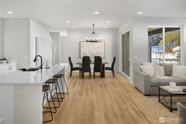 a living room with stainless steel appliances kitchen island granite countertop furniture wooden floor and a kitchen view