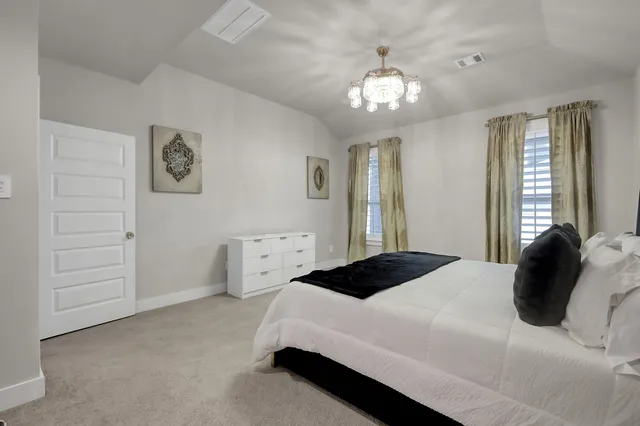a bedroom with a bed and a chandelier