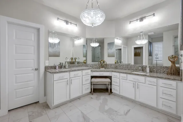 a spacious bathroom with a granite countertop sink a mirror and a vanity