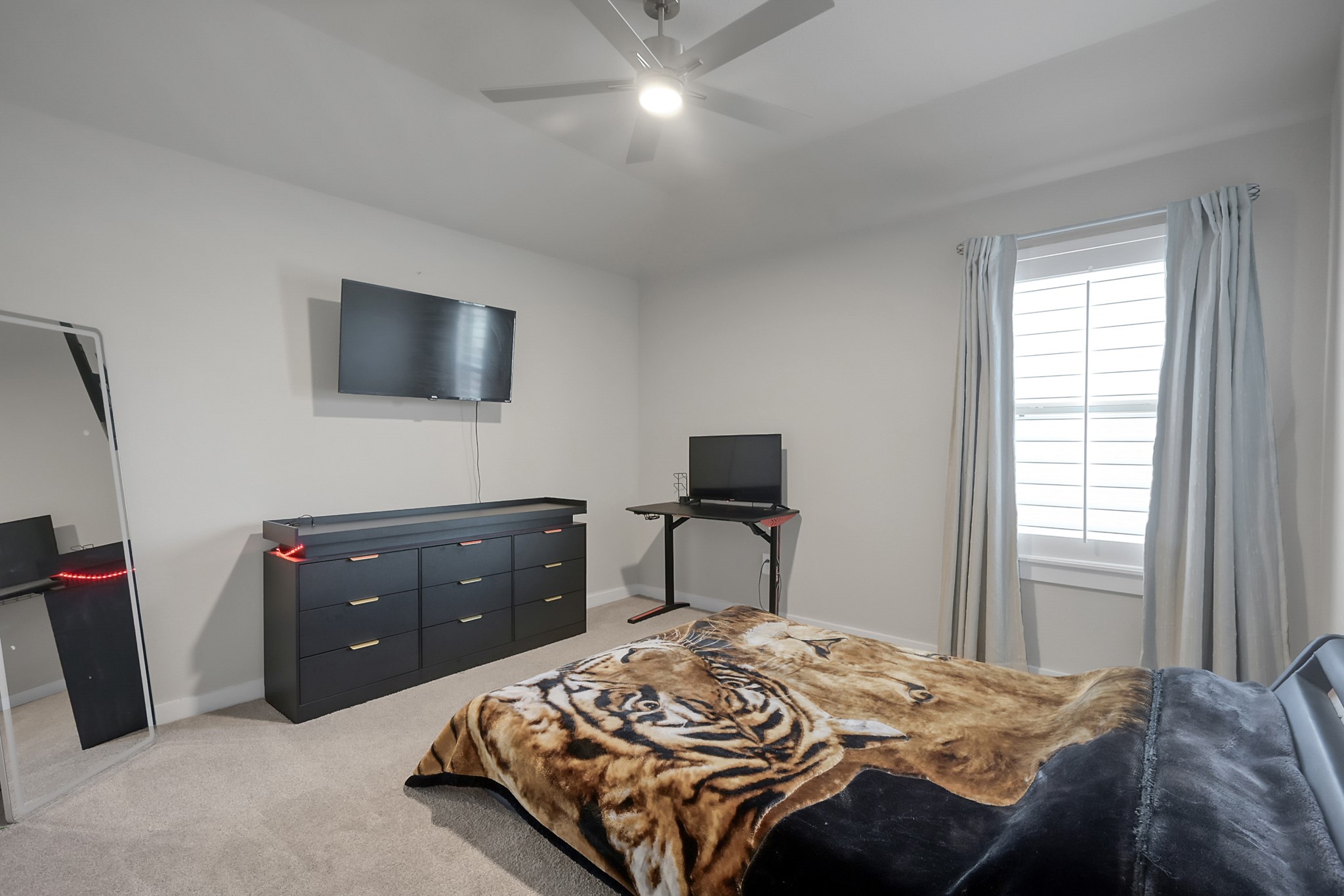 3131 Red Buckeye Lane Conroe, TX 77301 - Photo 26 of 34 a bedroom with a bed and a flat screen tv