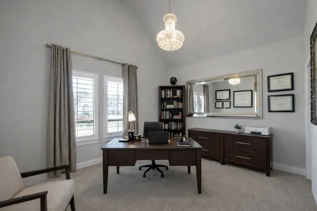 a view of a workspace with furniture and a window