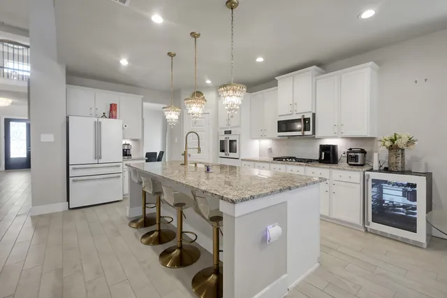 a kitchen with stainless steel appliances granite countertop a sink cabinets and wooden floor