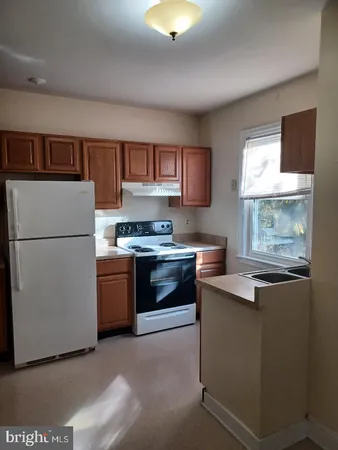 a kitchen with a refrigerator and a stove top oven