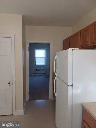 a white refrigerator freezer and a stove sitting inside of a kitchen