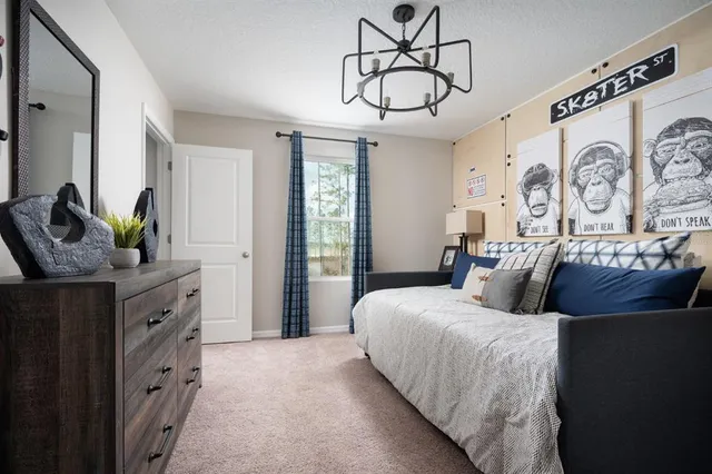 a bed sitting in a bedroom next to a lamp