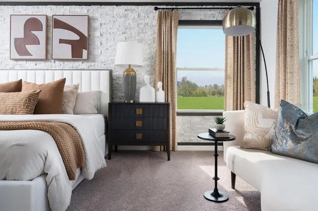 a bedroom with a bed and a potted plant on the dresser