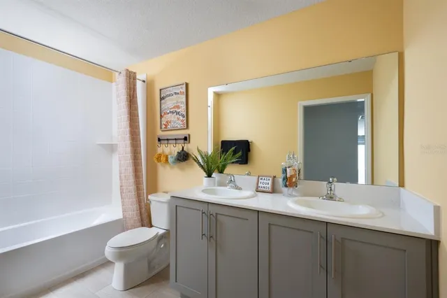 a bathroom with a double vanity sink toilet and shower
