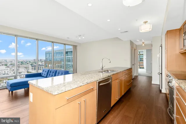 a large kitchen with kitchen island a large window and stainless steel appliances