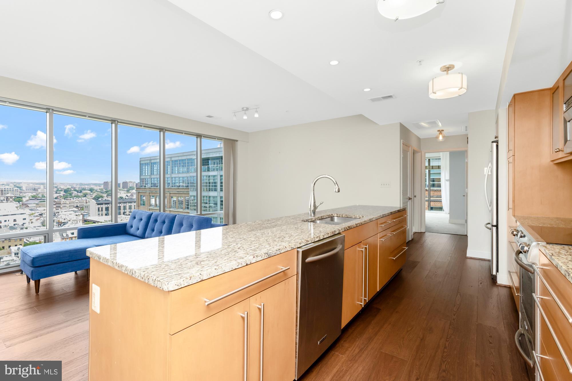 675 President Street, Unit 1406 Baltimore, MD 21202 - Photo 12 of 30 a large kitchen with kitchen island a large window and stainless steel appliances