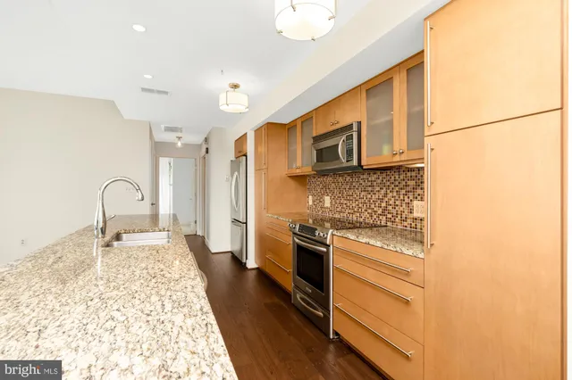 a kitchen with stainless steel appliances granite countertop a stove a sink and a refrigerator