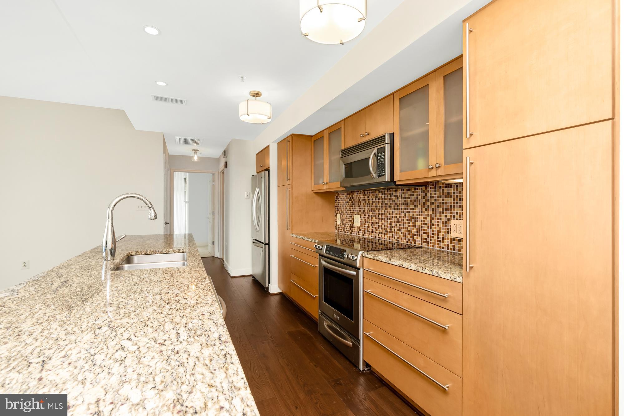 675 President Street, Unit 1406 Baltimore, MD 21202 - Photo 13 of 30 a kitchen with stainless steel appliances granite countertop a stove a sink and a refrigerator