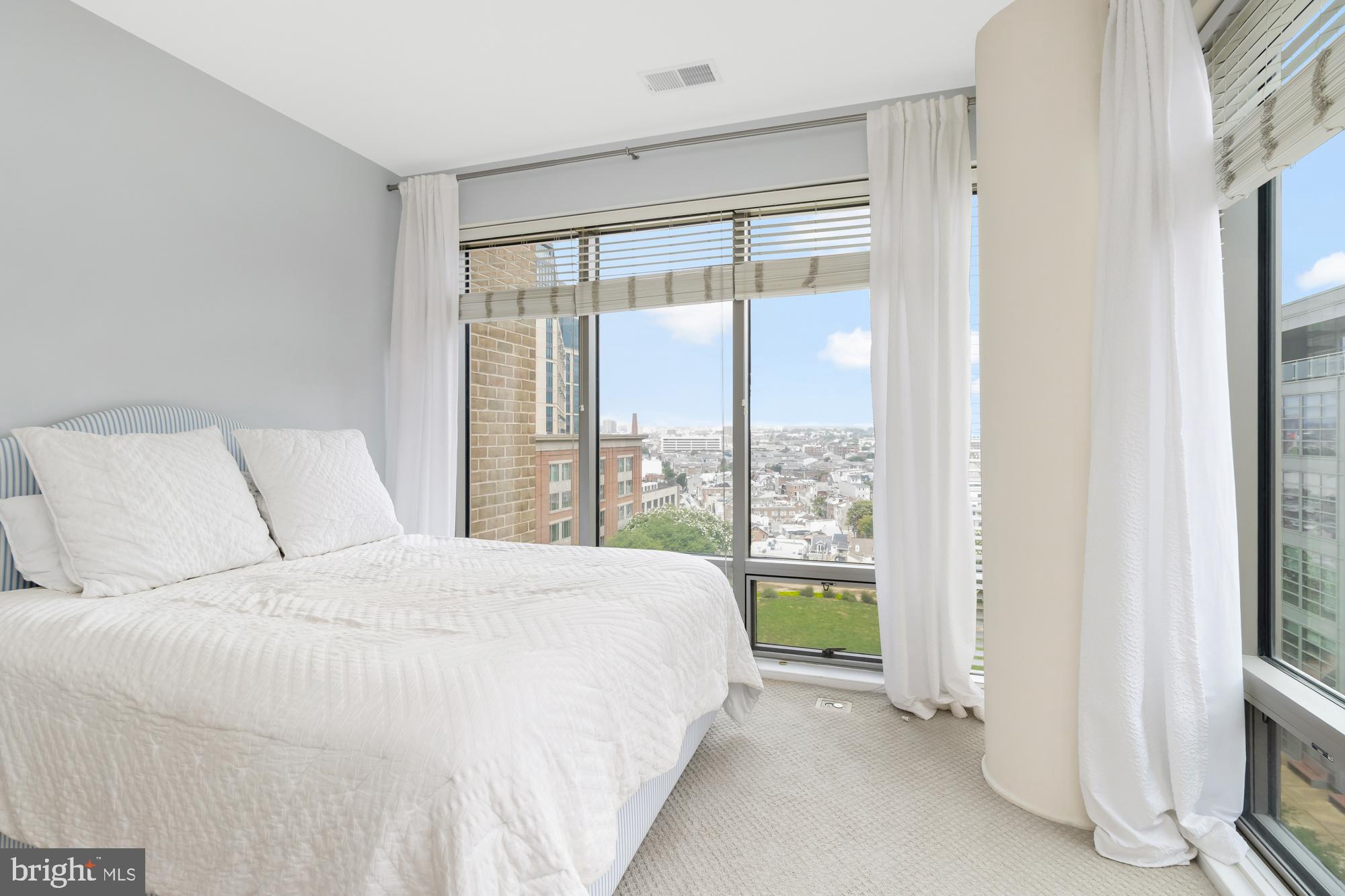 675 President Street, Unit 1406 Baltimore, MD 21202 - Photo 22 of 30 a large white bed sitting in a bedroom next to a window