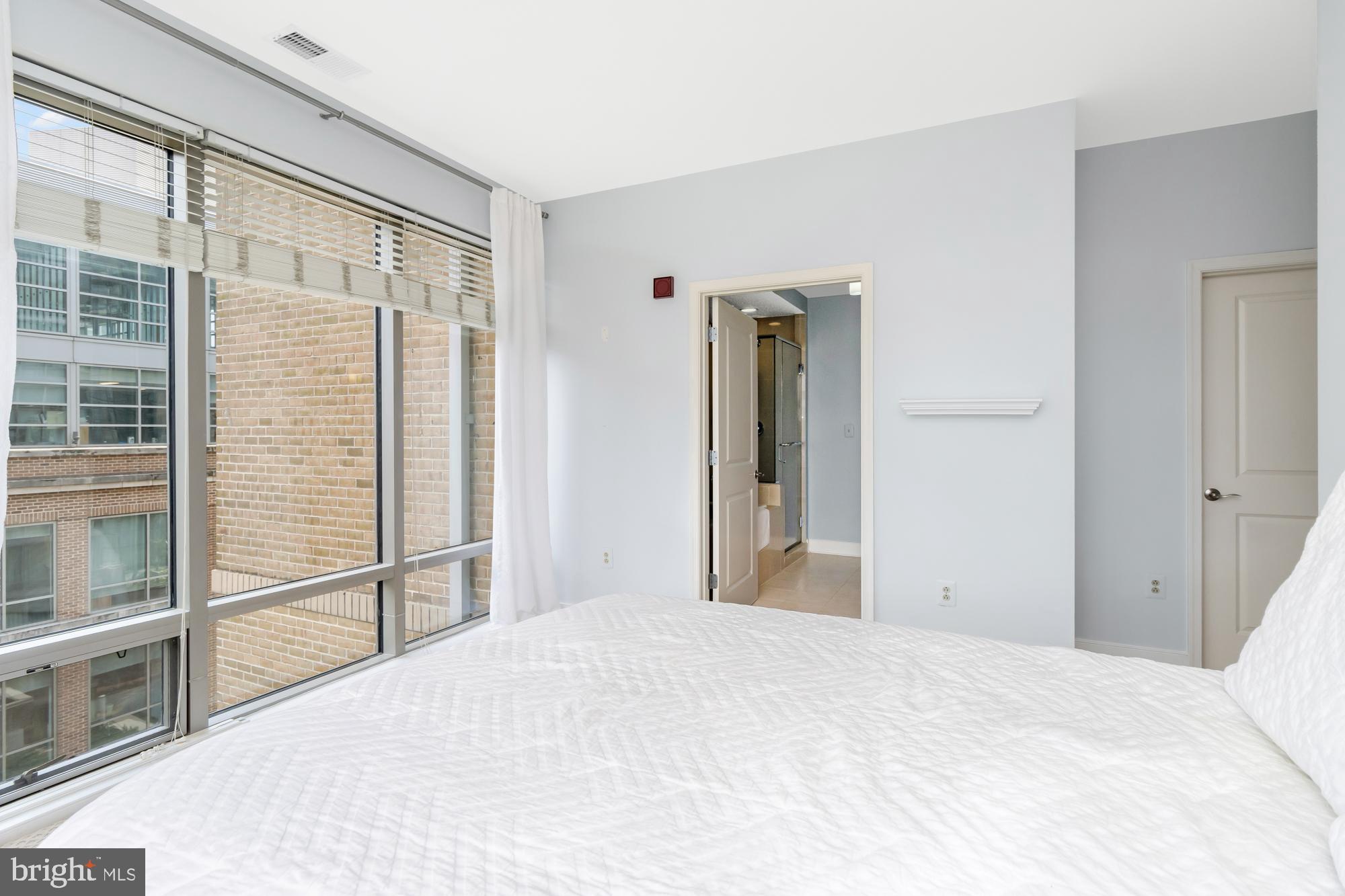 675 President Street, Unit 1406 Baltimore, MD 21202 - Photo 24 of 30 a bedroom with a bed and a large window