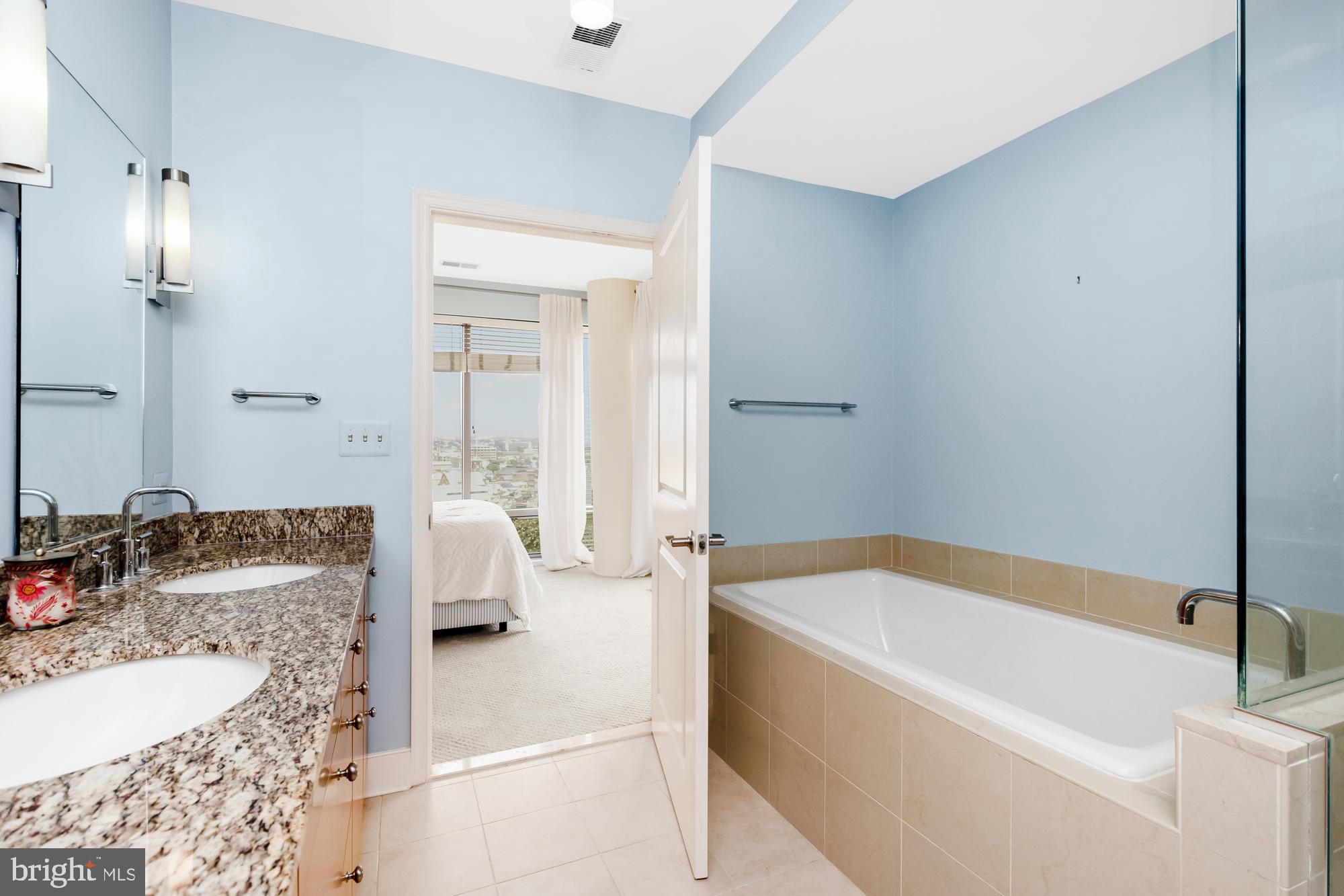 675 President Street, Unit 1406 Baltimore, MD 21202 - Photo 26 of 30 a bathroom with a granite countertop tub sink and mirror