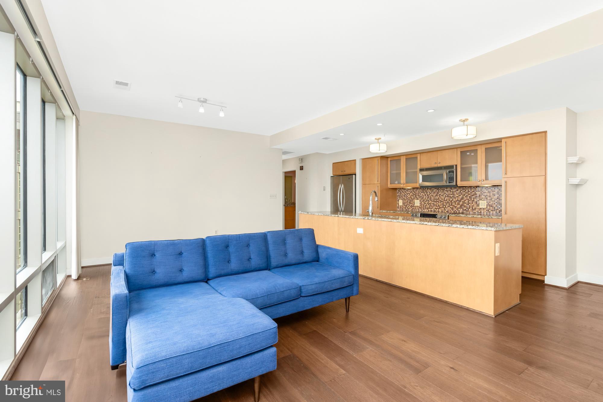 675 President Street, Unit 1406 Baltimore, MD 21202 - Photo 3 of 30 a living room with stainless steel appliances kitchen island granite countertop wooden floor and view living room