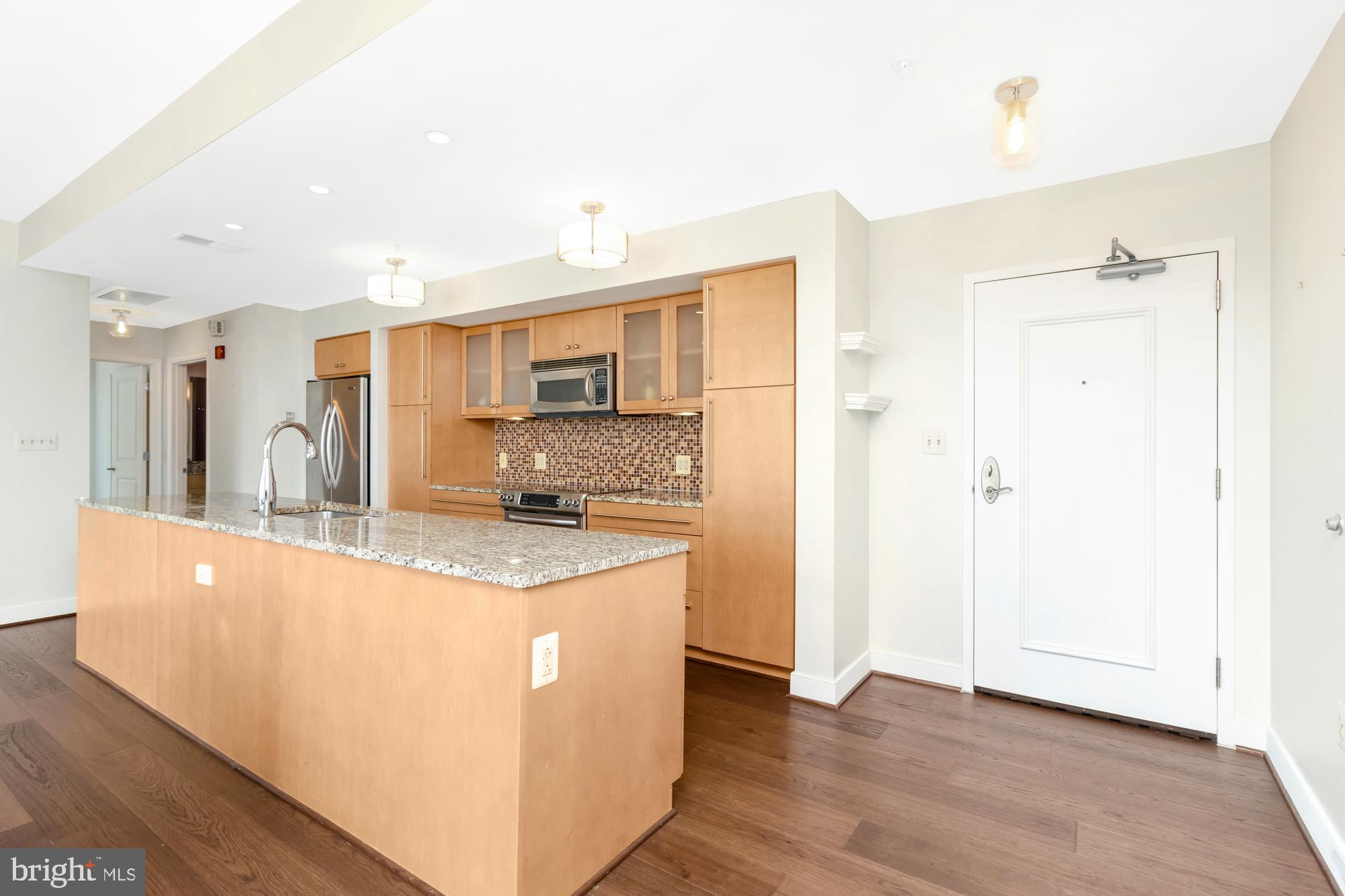 675 President Street, Unit 1406 Baltimore, MD 21202 - Photo 8 of 30 a kitchen with stainless steel appliances granite countertop a sink and a refrigerator