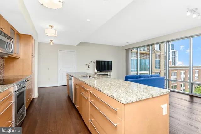 a kitchen with granite countertop a stove and a wooden floors