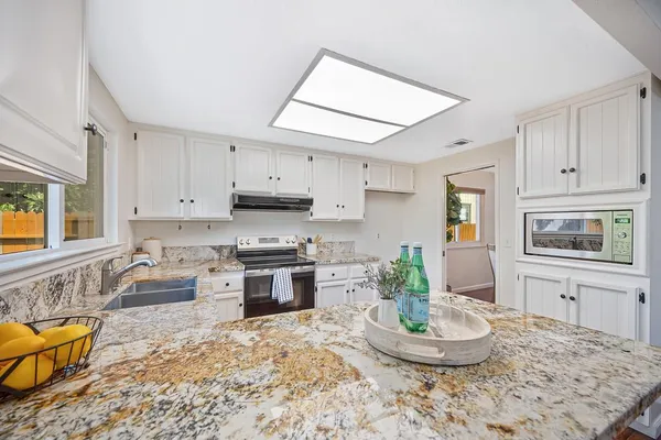 a dining room with wooden floor a chandelier a wooden table and chairs
