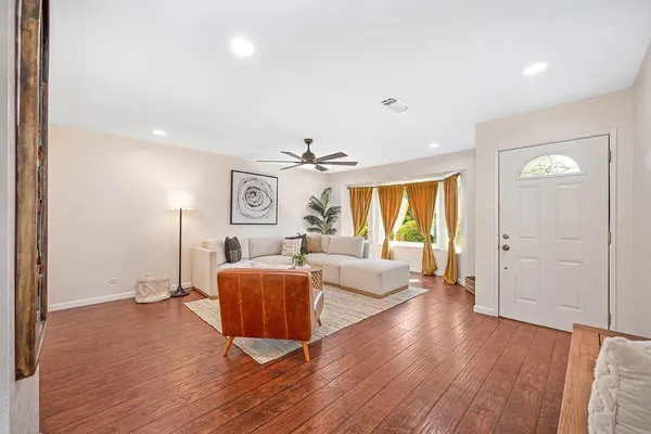 a living room with furniture and wooden floor