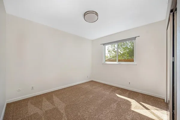 a bedroom with a bed and a painting on the wall