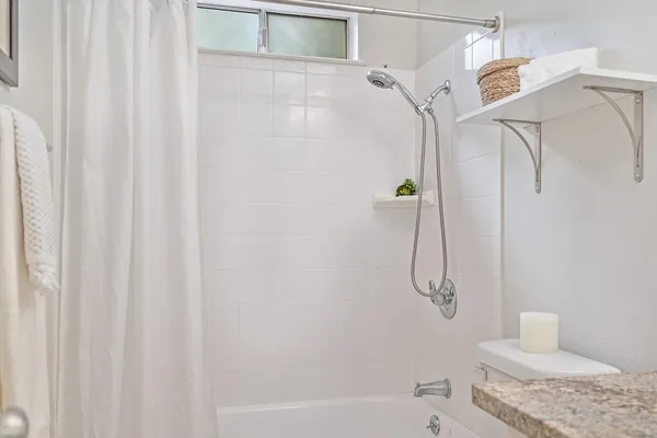 a spacious bathroom with a double vanity sink a toilet and a tub