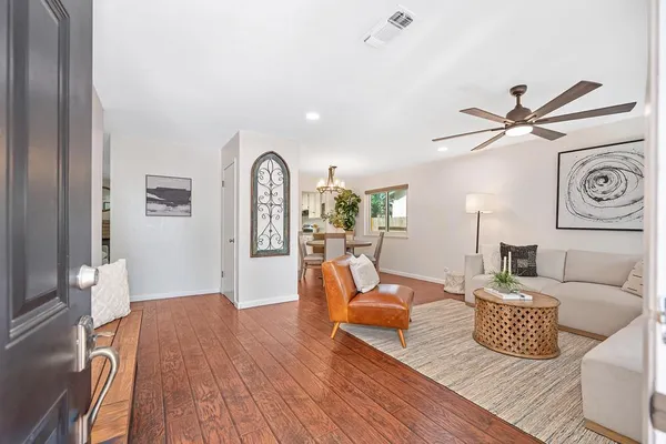 a kitchen with stainless steel appliances white cabinets and wooden floor