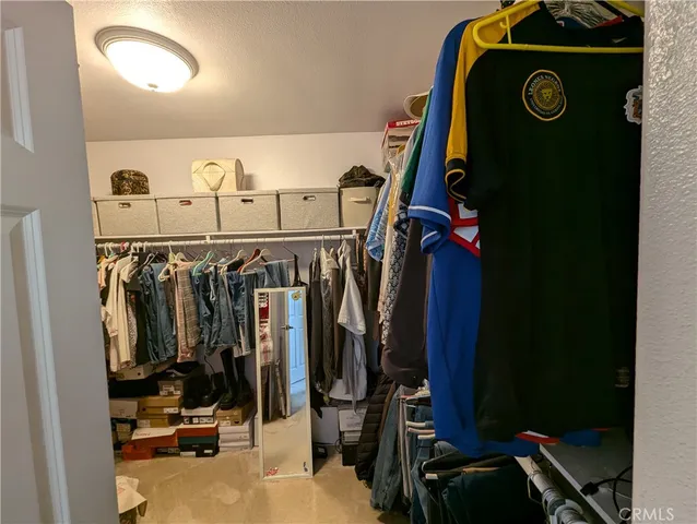 a view of walk in closet with clothes