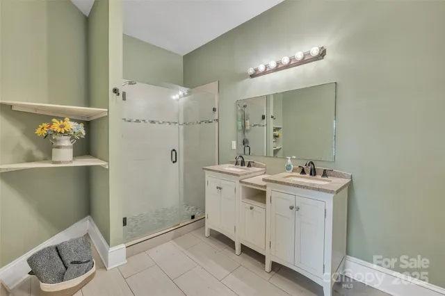 a spacious bathroom with a double vanity sink a toilet and a mirror