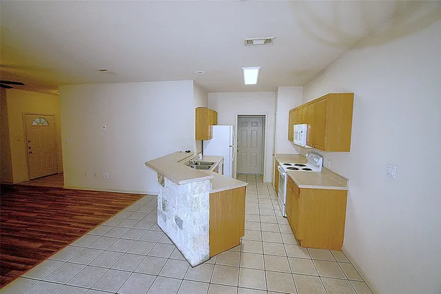 a kitchen with sink and mirror