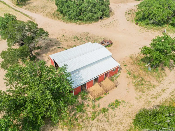 an aerial view of a house with a yard and large trees