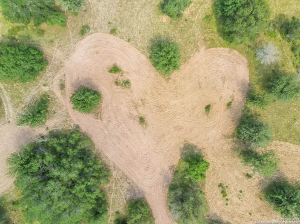 an aerial view of a house with a yard and trees