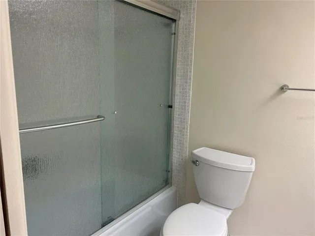 a white toilet sitting next to a shower