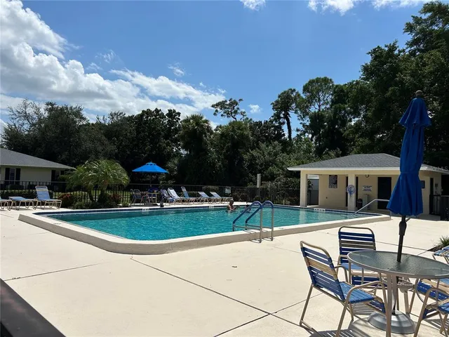 a view of a patio with a table and chairs under an umbrella