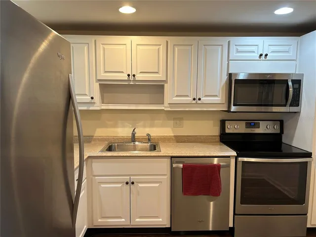 a kitchen with stainless steel appliances granite countertop a sink stove and microwave