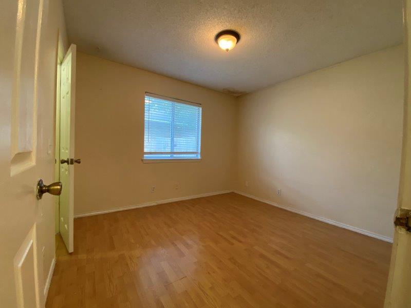 1903 Balsam Way Round Rock, TX 78665 - Photo 13 of 21 Natural light filters into this bedroom 2, featuring handsome wood flooring and a classic ceiling fixture.