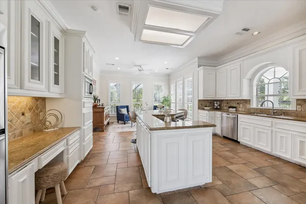 a kitchen with granite countertop a stove top oven and cabinets