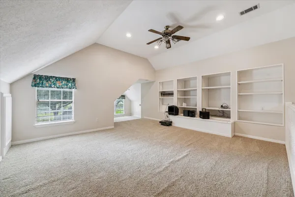 a view of empty room with windows and ceiling fan
